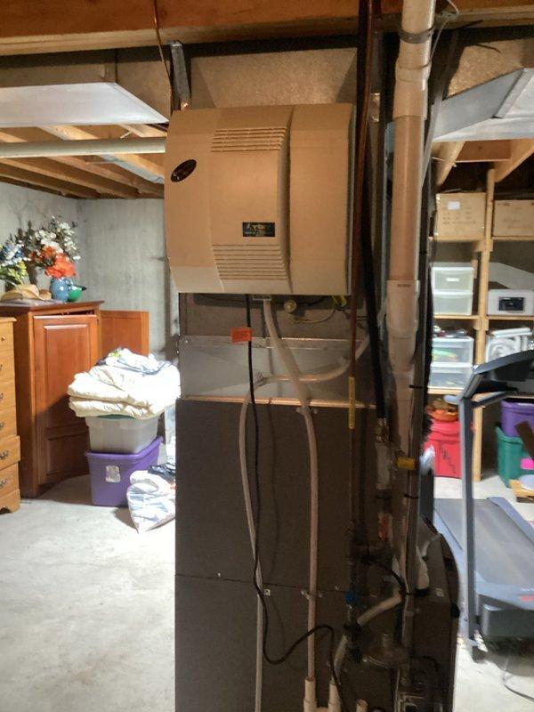 Conducted inspection of basement plumbing system, focusing on humidifier valve installation. Provided estimate for switching humidifier valve from cold water line to hot water line and repairing the existing cold water line. Documented current setup with photos of the HVAC system and exposed copper piping in ceiling joists.