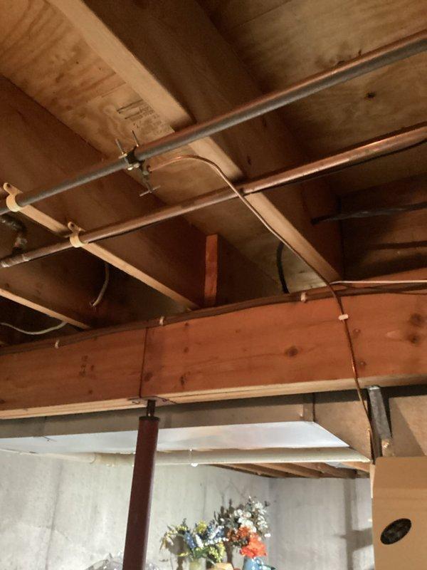 Conducted inspection of basement plumbing system, focusing on humidifier valve installation. Provided estimate for switching humidifier valve from cold water line to hot water line and repairing the existing cold water line. Documented current setup with photos of the HVAC system and exposed copper piping in ceiling joists.