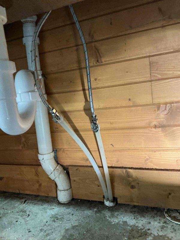 Replaced customer-supplied faucet on utility sink in garage, which included installing a new shut-off valve. Inspected existing PVC drainage system and supply lines mounted on wooden wall panel, ensuring proper connection to new fixtures and verifying system functionality after installation.