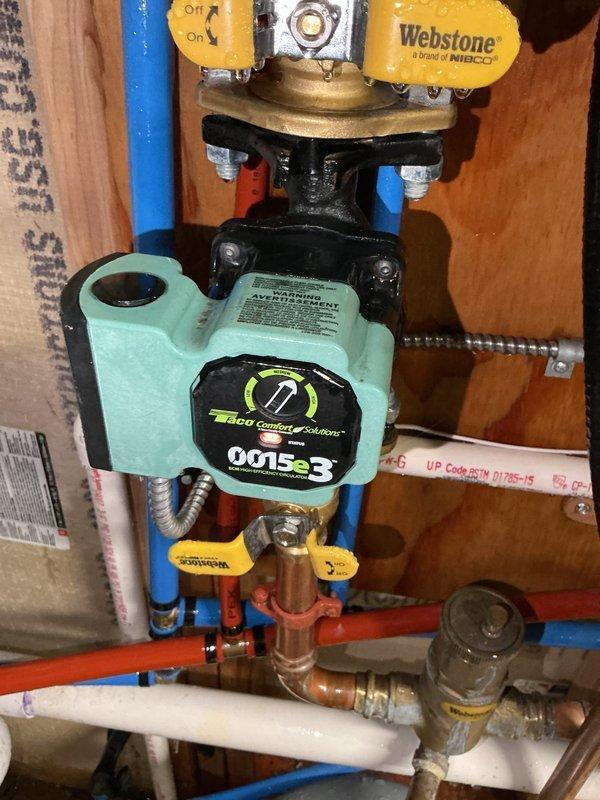 Responded to a no-heat service call for an aging boiler system with severe leakage. Diagnosed a hole in the original circulator pump causing complete system failure (no heat, no hot water). Successfully replaced the damaged unit with a new Taco 0015e3 ECM high-efficiency circulator pump, restoring full system functionality.