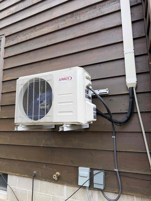 Responded to service call for a Lennox mini-split condenser unit that was improperly mounted and pulling away from the house siding. Technician reclaimed refrigerant, removed the unit, and properly reinstalled the mounting bracket using longer lag bolts secured to wall studs. After reinstallation, the system was evacuated, charged, and tested for proper operation, resolving the safety hazard and ensuring correct unit function.