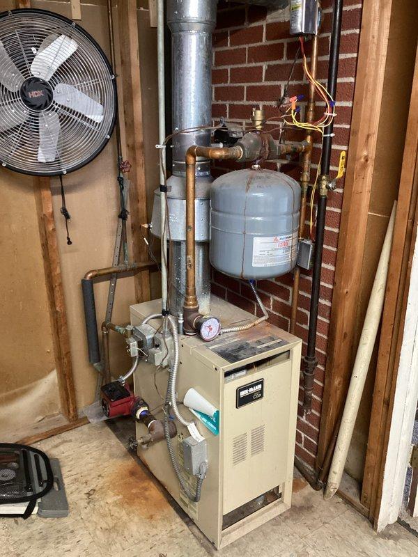 Responded to service call for Weil-McLain boiler system with complaint of new pump making loud noise and heating inconsistency. Diagnostic inspection revealed air trapped in system with no available bleeders. Recommended return visit by technician equipped to purge air from system or install appropriate bleeders to resolve noise issue and restore proper heating function.