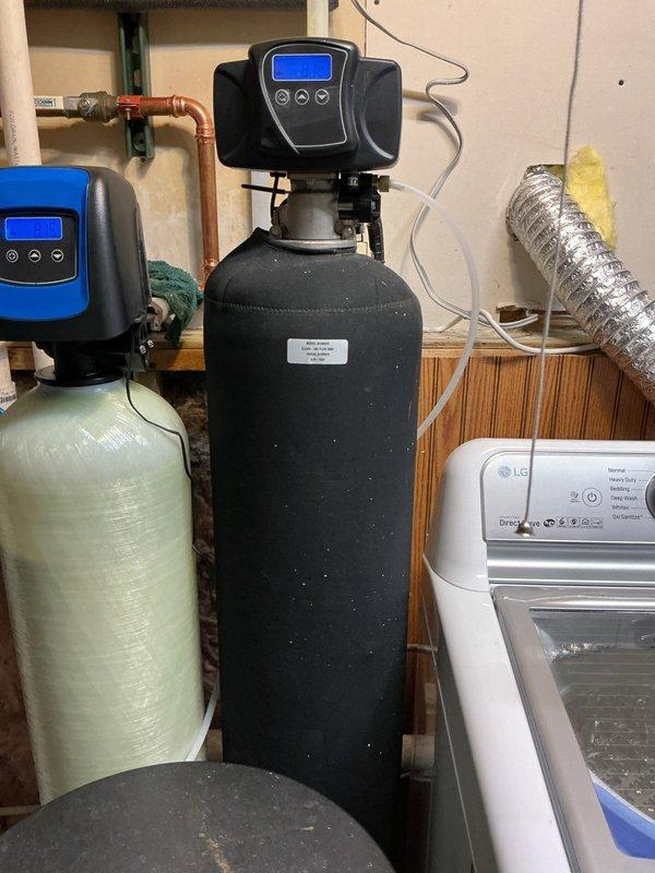 Responded to service call regarding dead fish odor from water system installed one month prior. Diagnosed issue with acid neutralizer causing strong fish smell, particularly pronounced in hot water supply. Tested water softener functionality (confirmed working), then bypassed softener and drained water heater which significantly reduced odor. Provided customer with instructions for properly flushing the water softener system to potentially resolve the remaining odor issue.