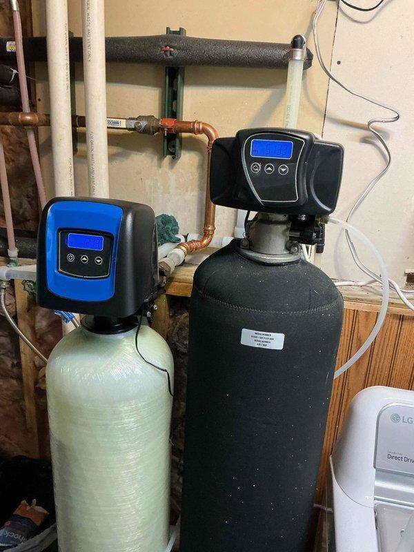 Performed follow-up visit for persistent fish-like odor in water supply after previous softener sanitization attempt failed to resolve the issue. Inspected dual water treatment system consisting of water softener with digital control head and larger secondary treatment tank. Customer informed that estimates for carbon filtration system installation have been provided as recommended solution to eliminate odor, and they are reviewing options before proceeding with treatment upgrade.