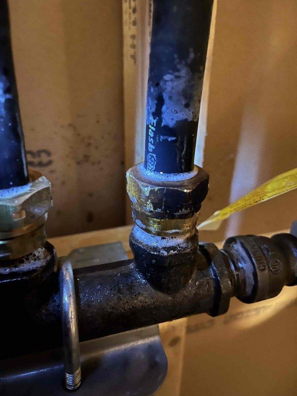 Responded to reported LP gas odor near range and in basement area. Performed systematic leak detection, beginning with inspection of range connection and gas supply line. No leak detected at stove location. Traced gas distribution system to basement branch line and identified loose fitting on gastite flexible gas line. Tightened fitting to proper torque specification and confirmed leak elimination through soap bubble test. System restored to safe operating condition.