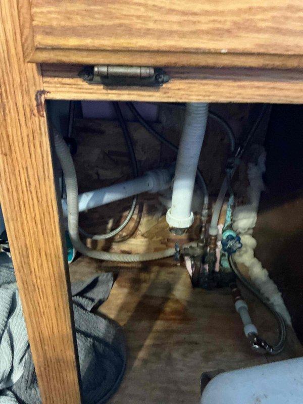 Responded to service call for kitchen sink drainage issue. Upon inspection, discovered ice formation in drain line causing the clog. Recommended placing a space heater under the cabinet to thaw the frozen section and advised customer to contact professional steam service if not resolved within 24 hours.